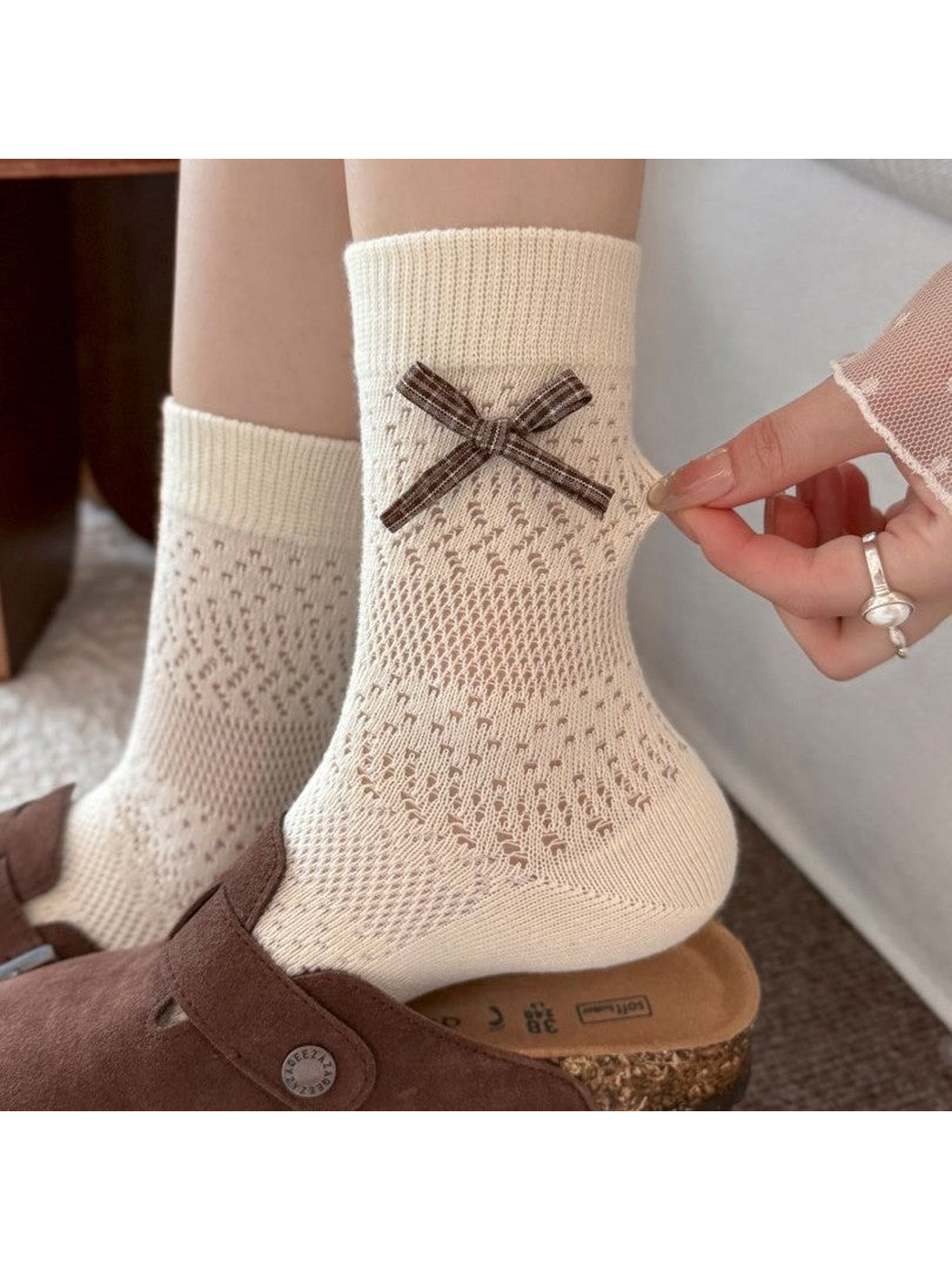 Beige bow crew socks worn with brown clogs
