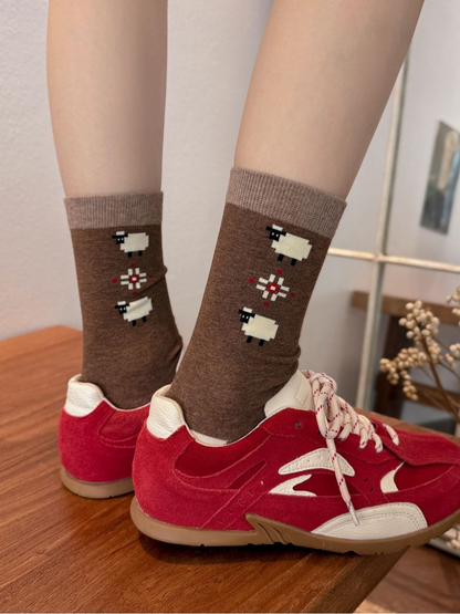 Geometric sheep-motif crew socks worn with red sneakers