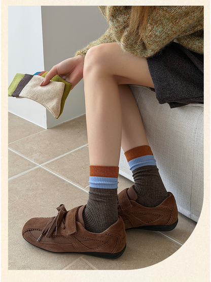 Dark Brown color-block crew socks worn with brown shoes while additional colors are held