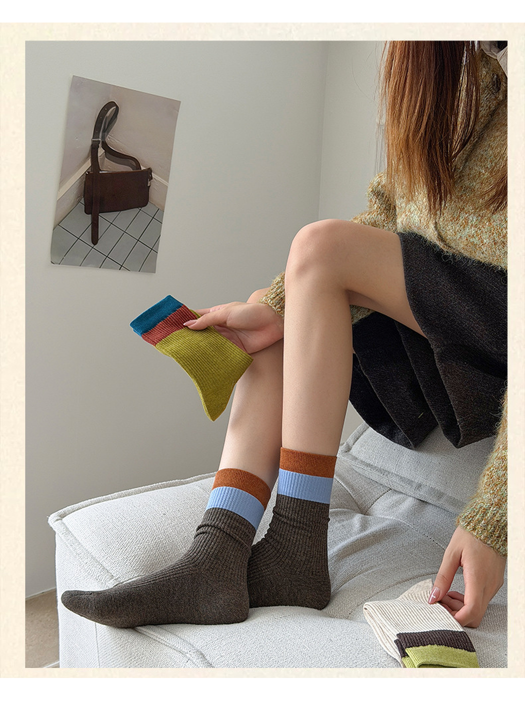 Dark Brown ribbed crew socks with light blue and orange cuff bands worn while seated