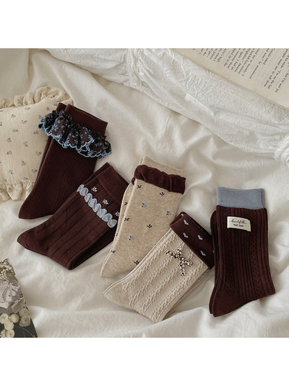 Five crew sock styles arranged together on neutral bedding