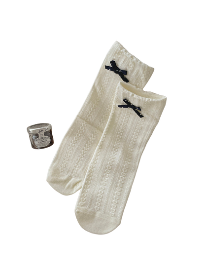 Ivory crew socks with bow accents and a textured vertical pattern