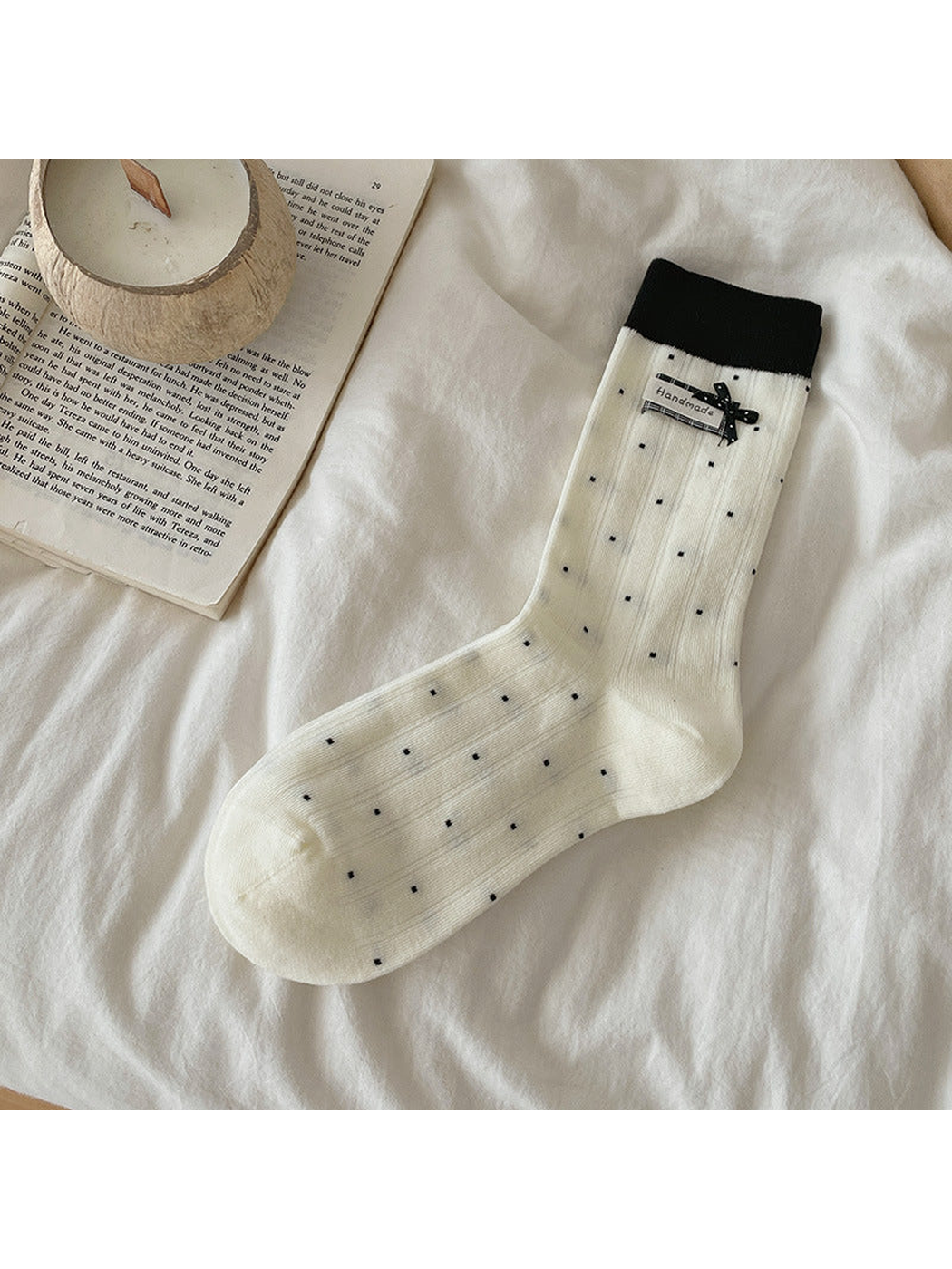Ivory polka-dot crew sock with black cuff and bow accent