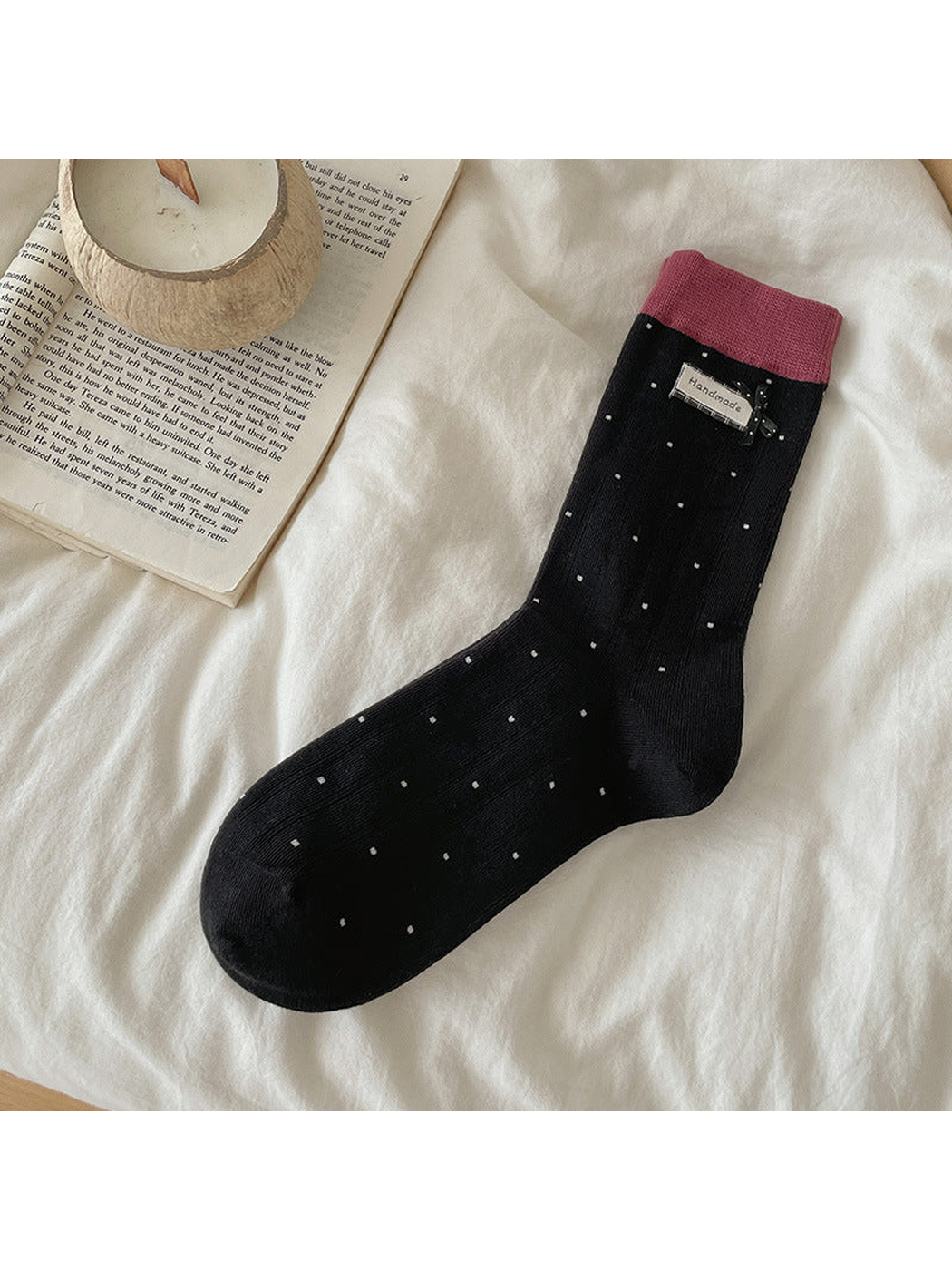 Black polka-dot crew sock with pink cuff and bow accent