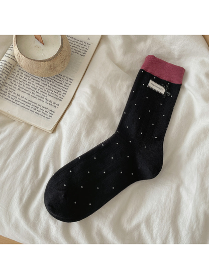 Black polka-dot crew sock with pink cuff and bow accent