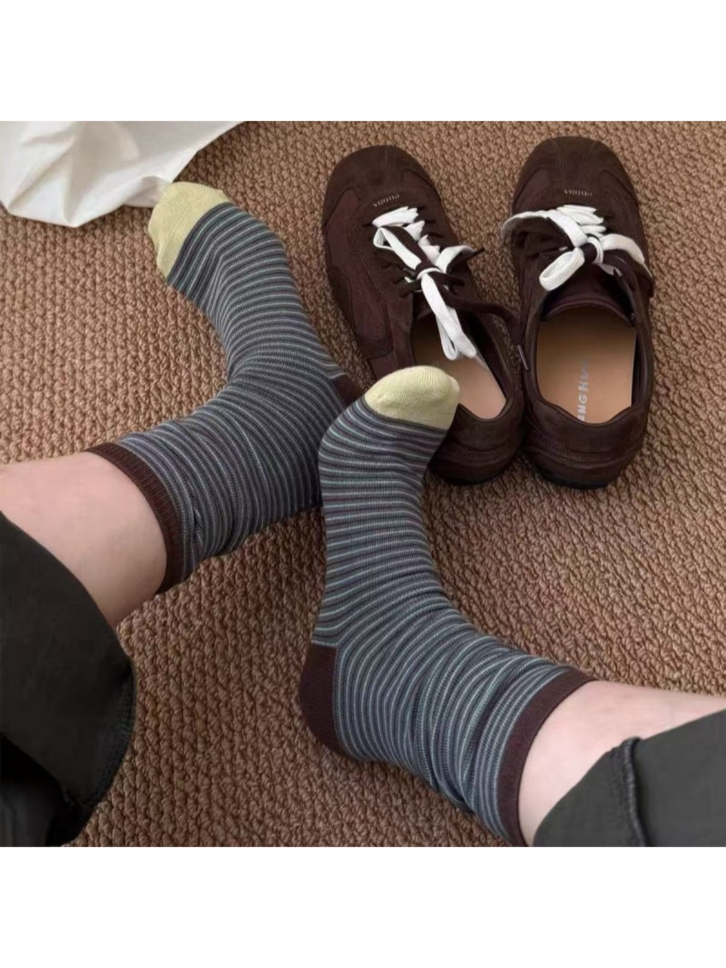 Yellow striped crew socks worn beside brown sneakers