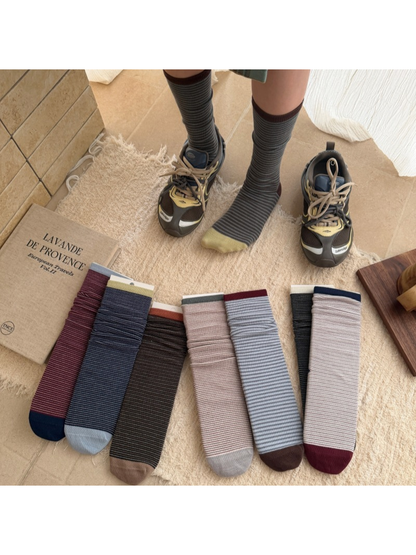 Yellow striped crew socks worn with sneakers beside multiple color options