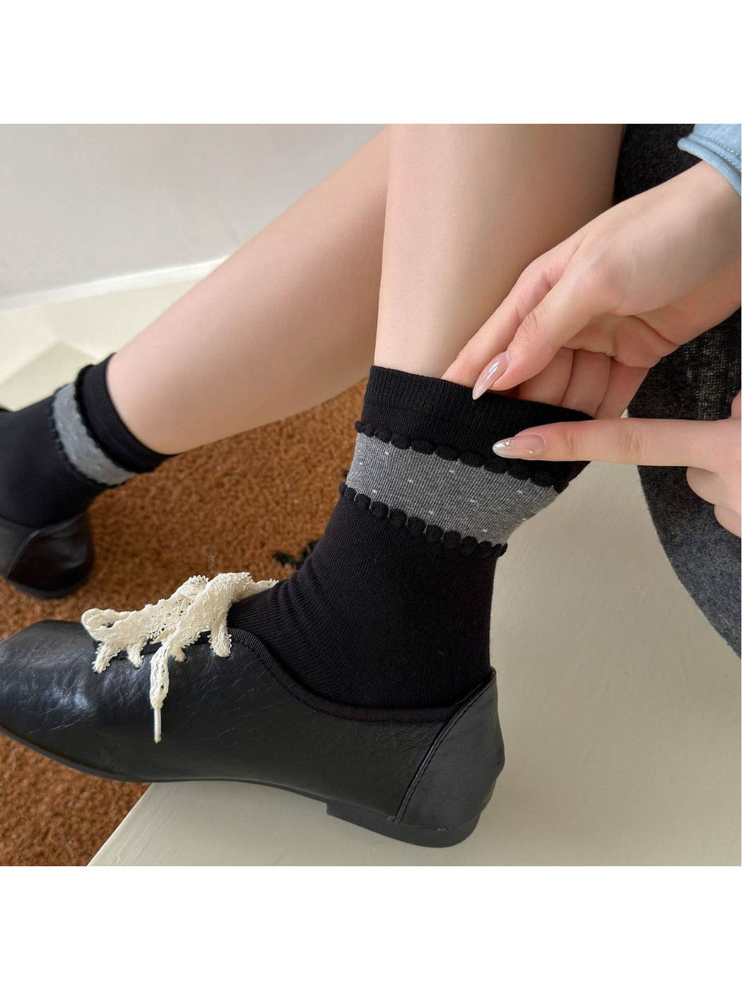 Close-up of a Black sock with a dotted gray ankle band and raised looped trim