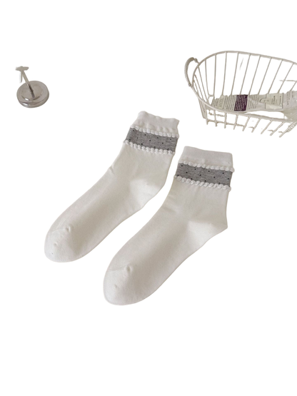 White crew socks with a gray dotted ankle band and raised trim