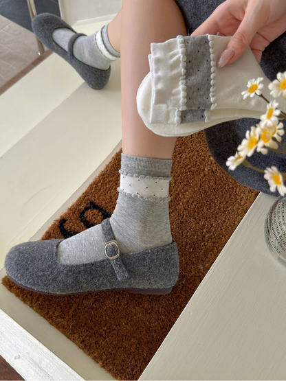 Close-up of Gray socks worn with a white sock pair held above