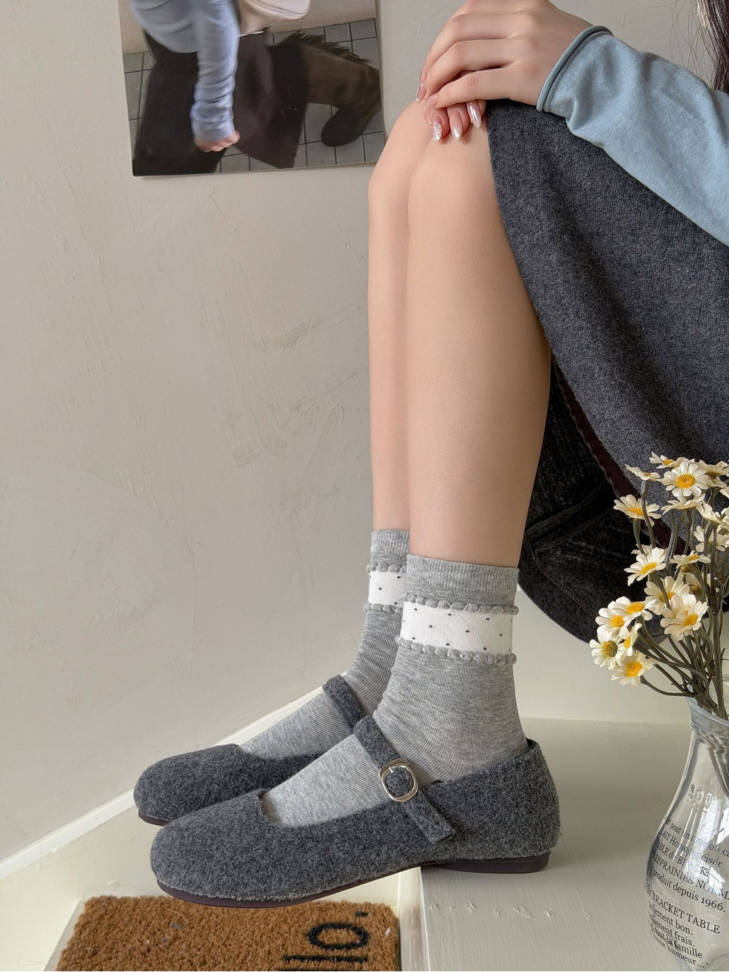 Gray crew socks with white dotted ankle bands styled with gray shoes