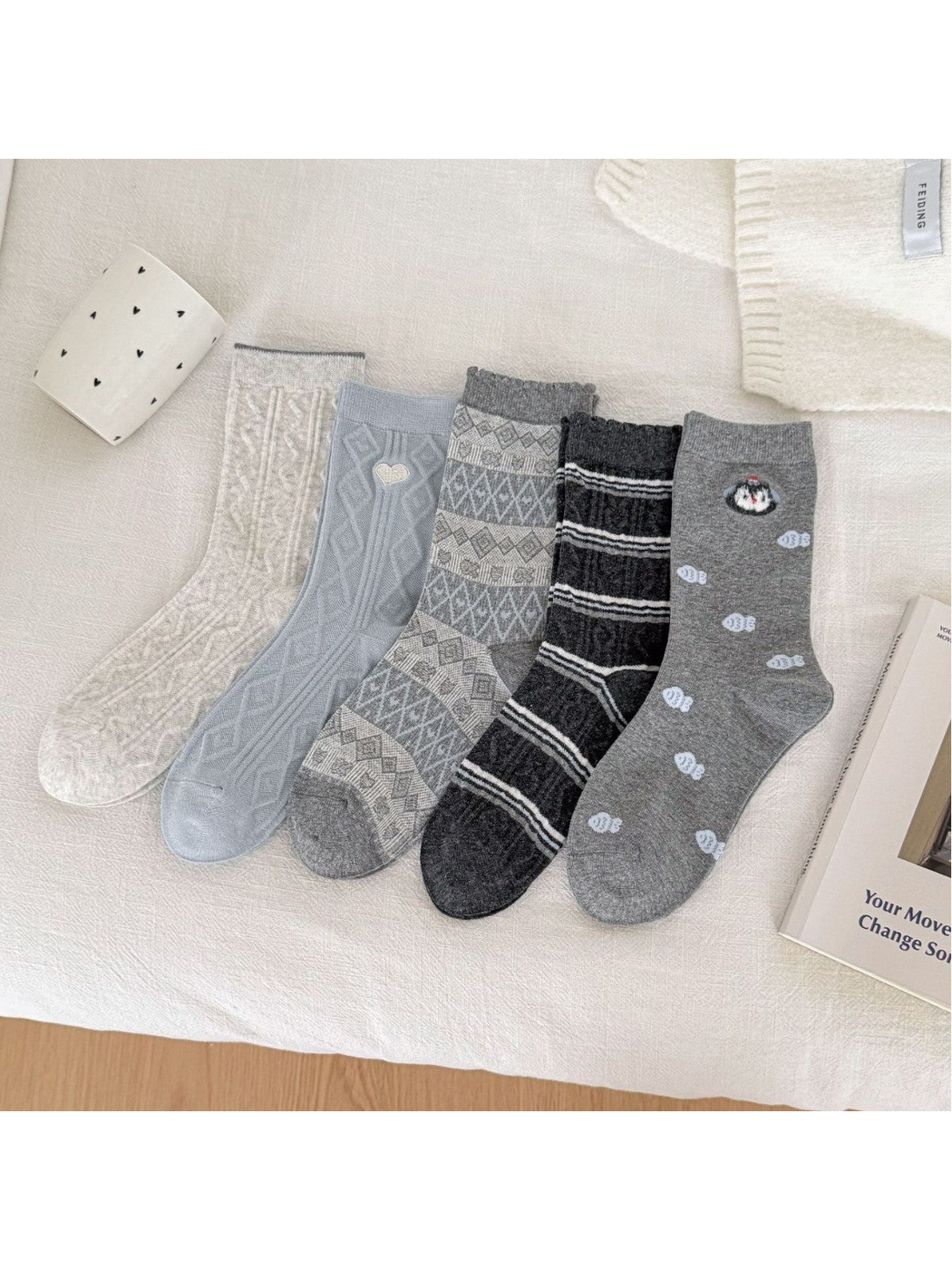 Five crew sock styles displayed together in ivory, blue and gray