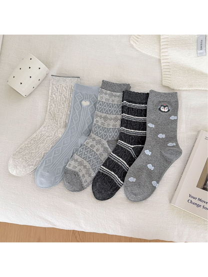 Five crew sock styles displayed together in ivory, blue and gray
