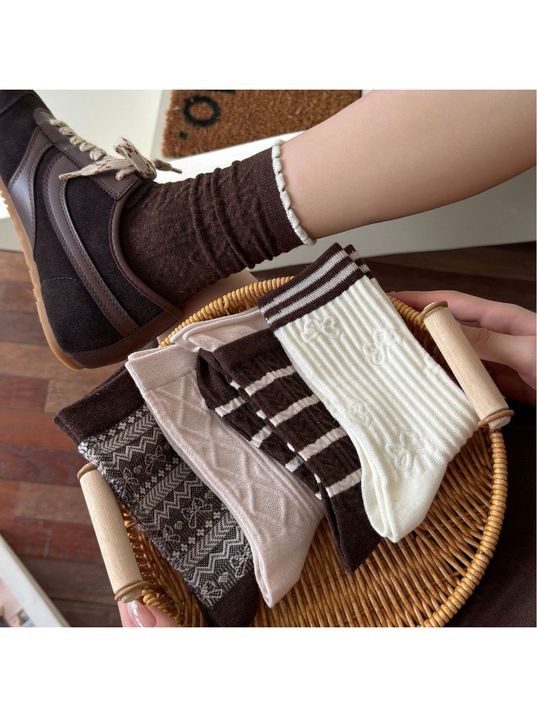 Assorted crew sock styles arranged in a basket beside a brown sock worn with a sneaker
