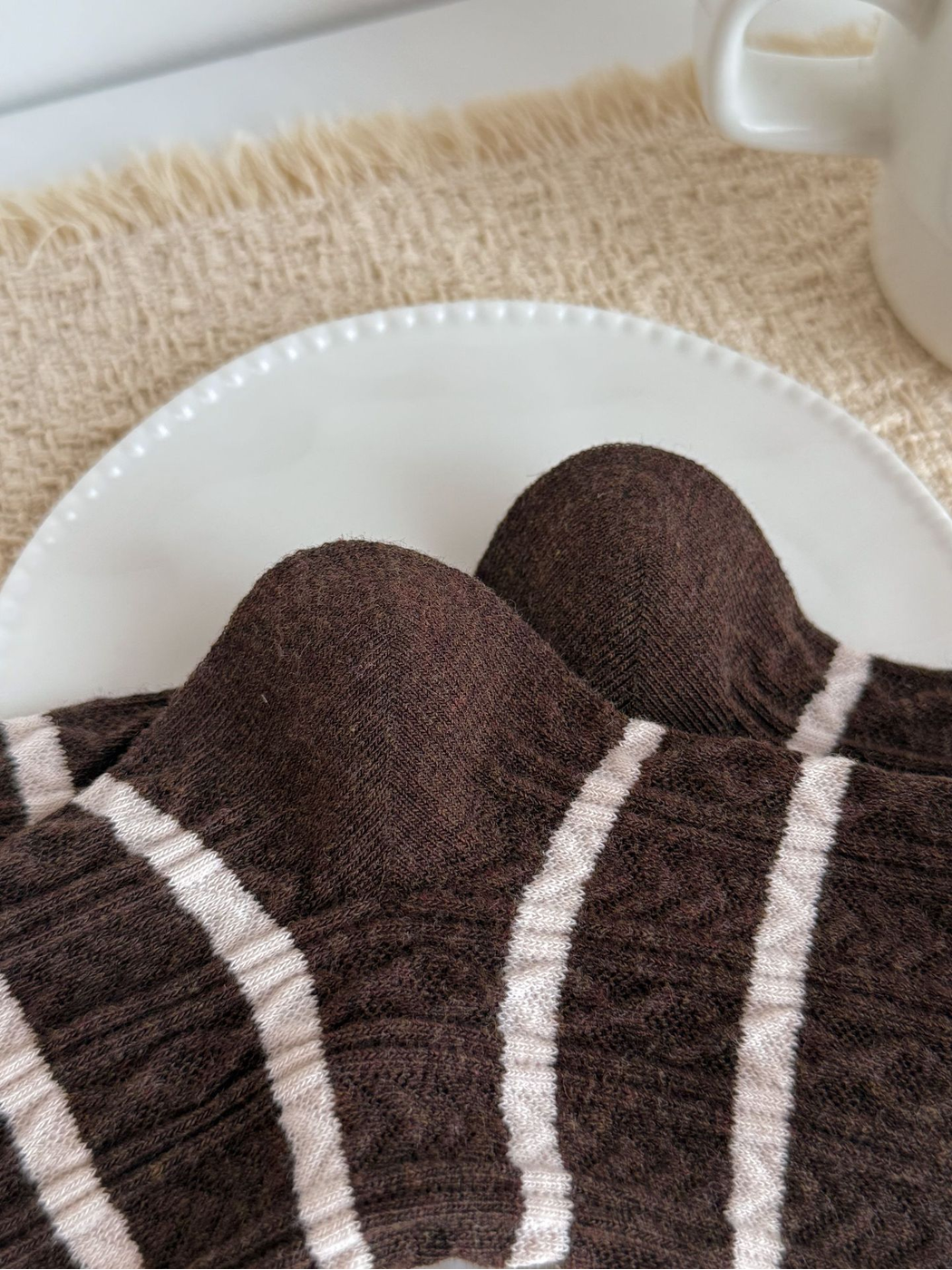 Close-up of the striped socks' curved toe seams and textured knit