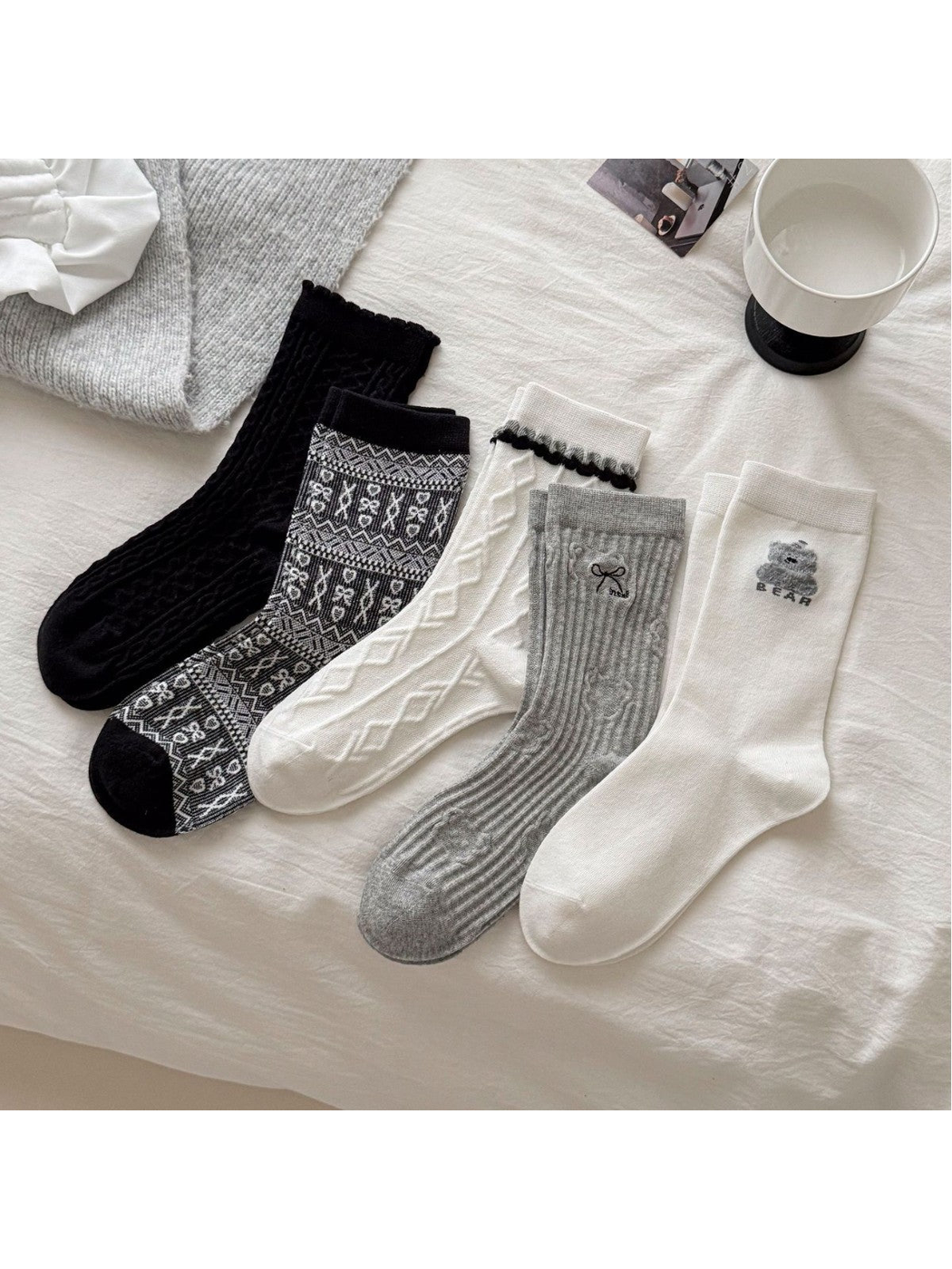 Five crew sock styles displayed together in black, gray and ivory