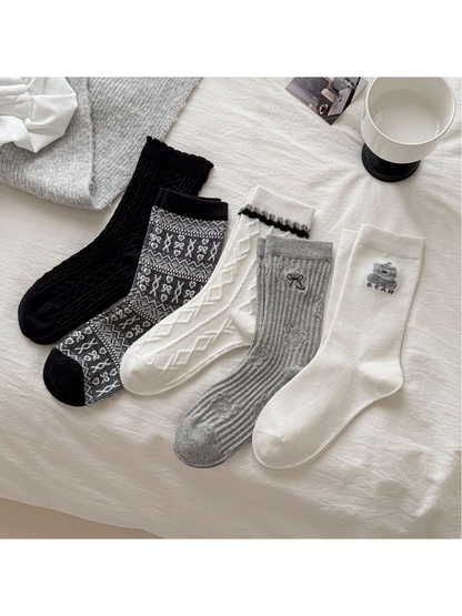 Five crew sock styles displayed together in black, gray and ivory