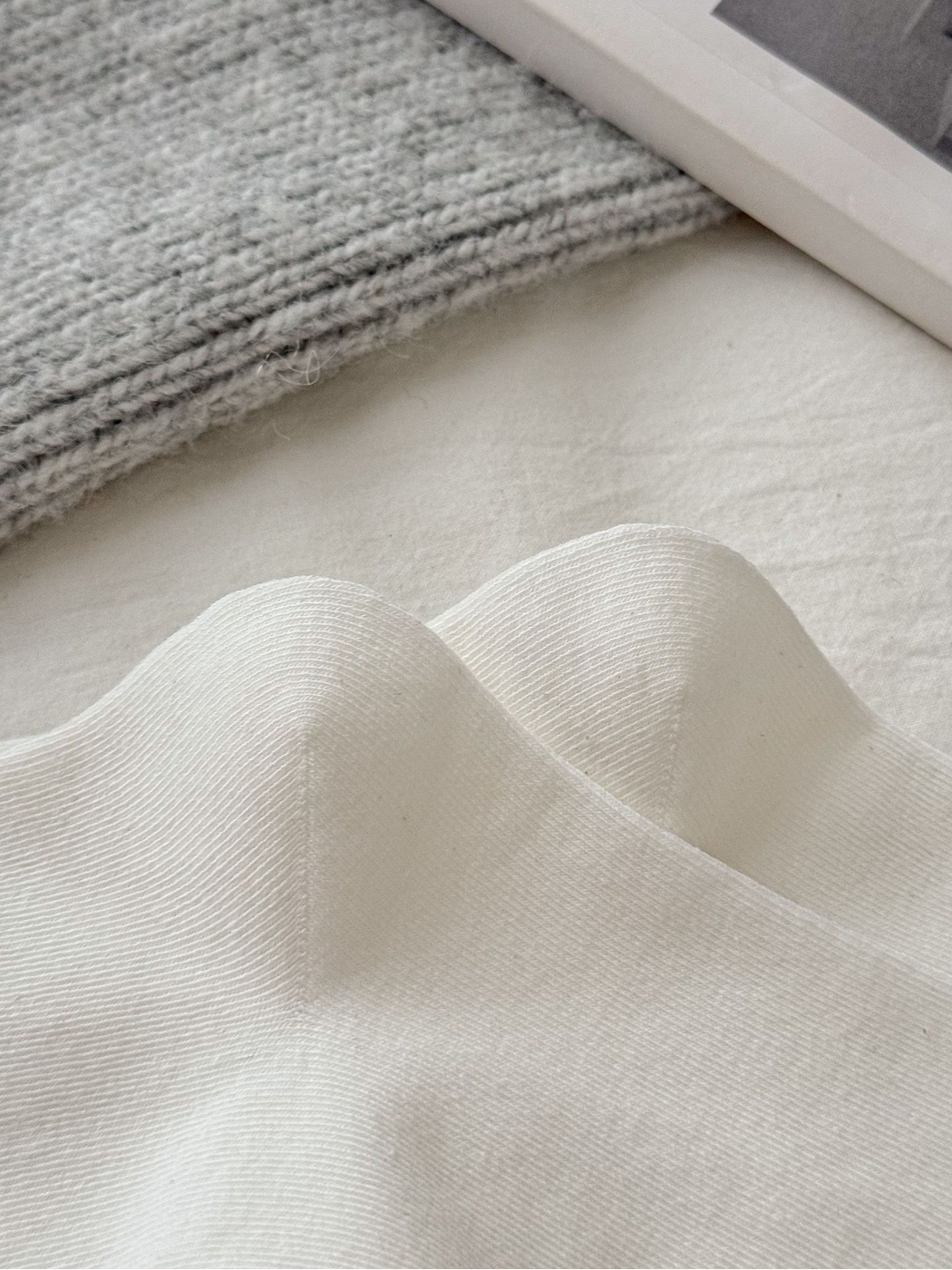 Close-up of the fine knit texture on ivory socks