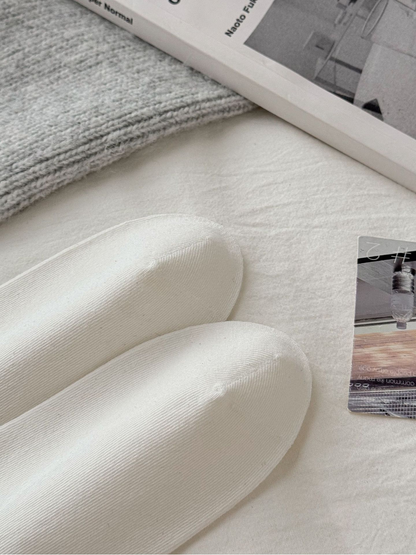 Close-up of the rounded toes and visible seams on ivory socks