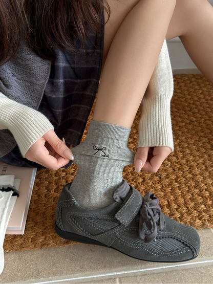 Bow style gray crew sock worn with a gray sneaker