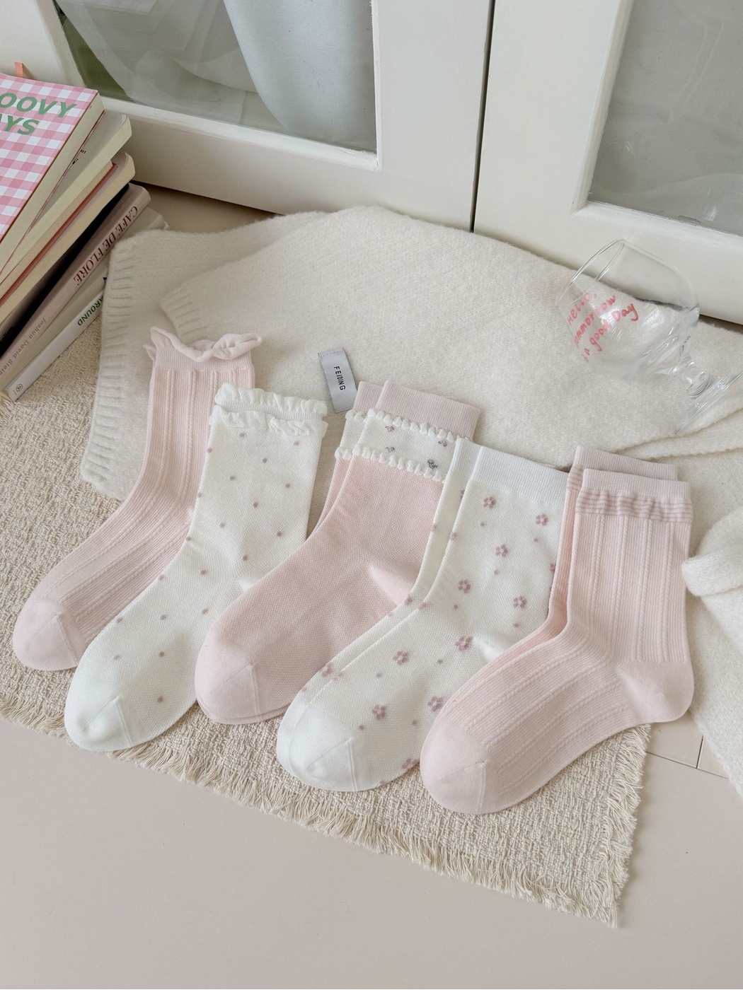 Five ivory and pink crew sock styles arranged together in full-length views