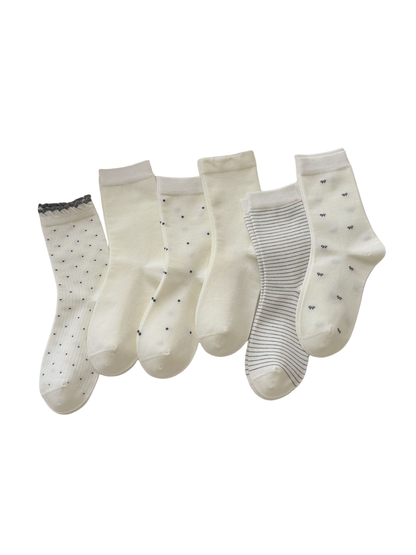 Five ivory crew sock styles displayed together, including dots, bows, solid and fine stripes