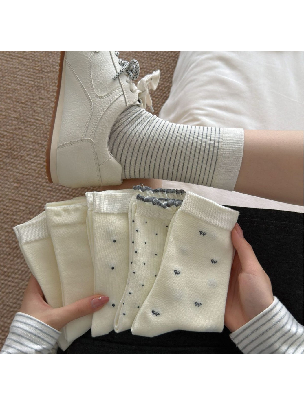 Fine stripe socks worn with white sneakers beside an assortment of ivory sock styles
