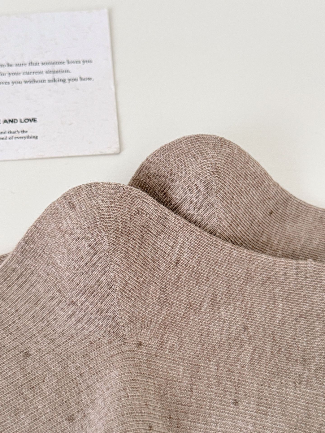 Close-up of the fine ribbed texture and scattered flecks on Light Coffee socks