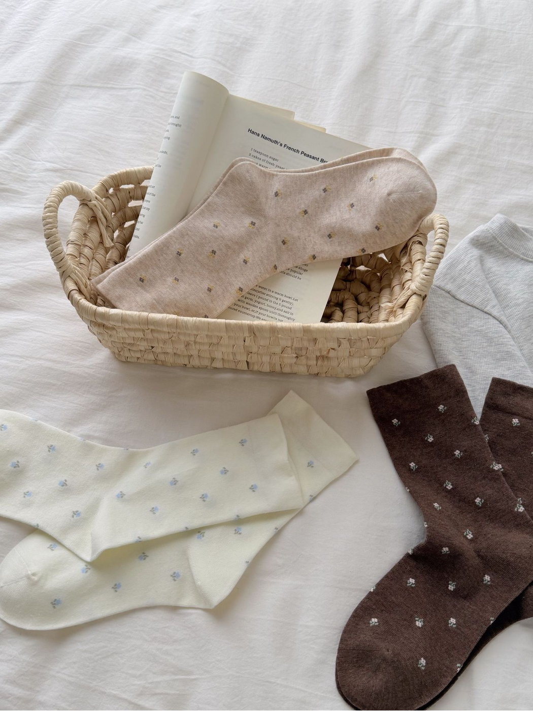 Ivory, Beige, Coffee and Light Gray floral crew socks arranged around a basket