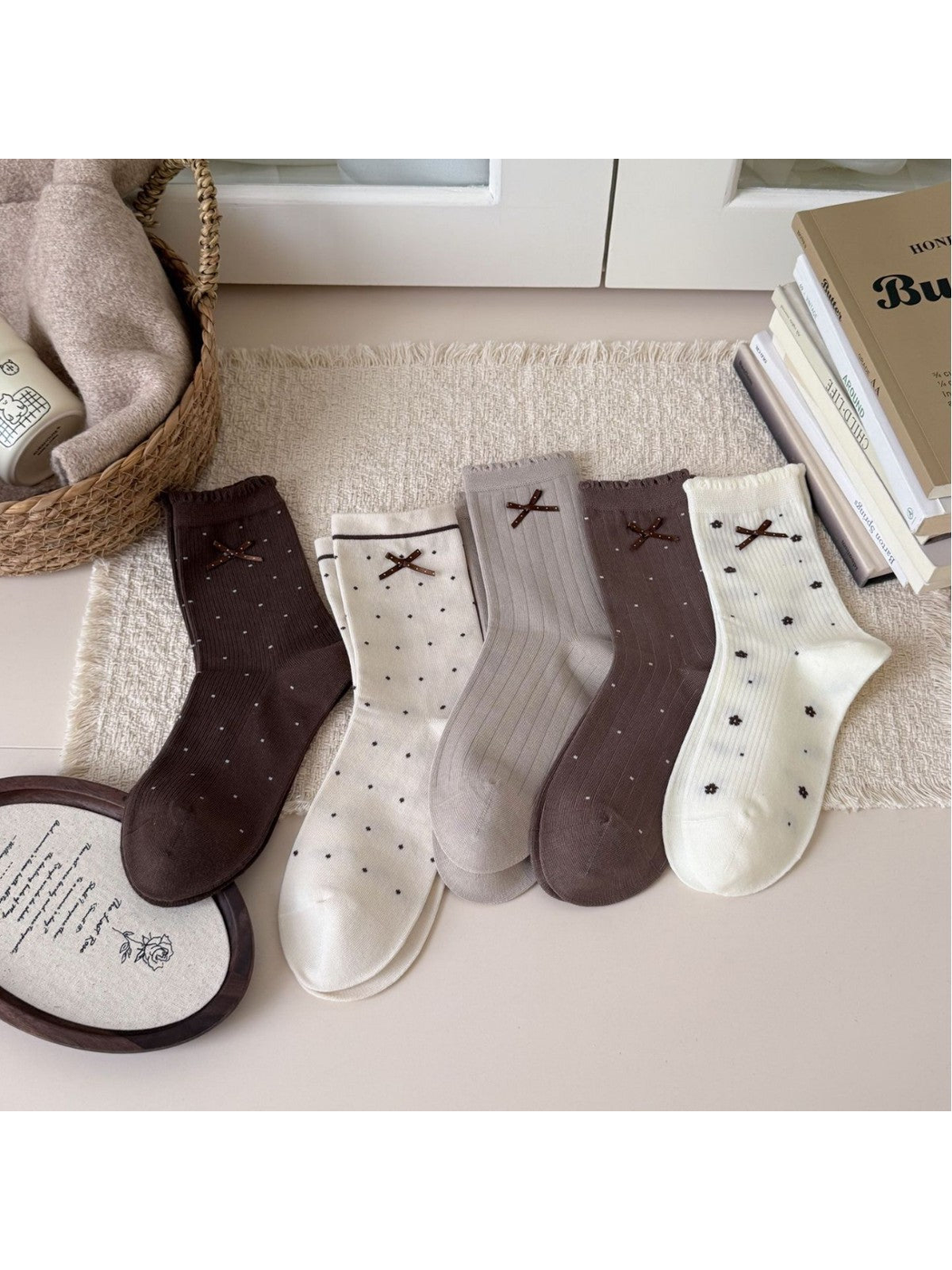 Ivory, beige, greige and brown crew socks with bow accents displayed together