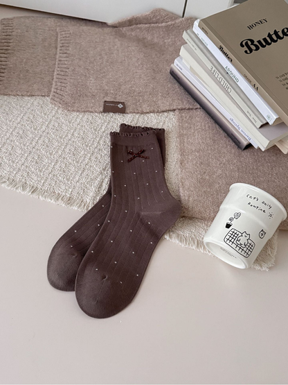 Brown crew socks with light polka dots, ruffled cuffs and bow accents