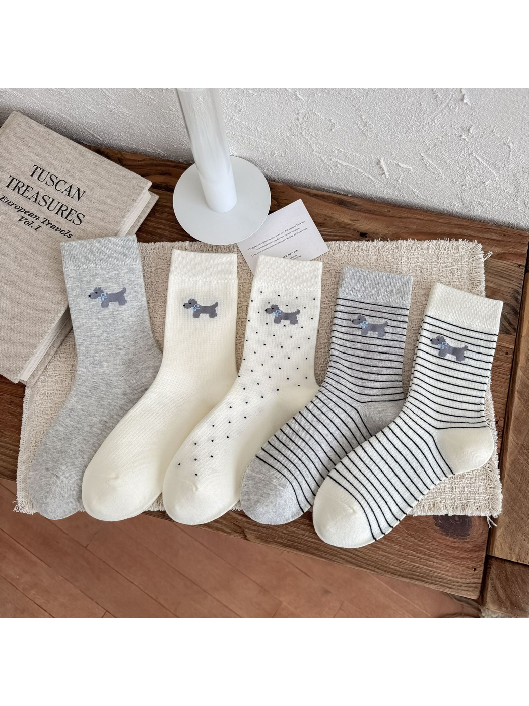 Five ivory and gray crew sock styles with dog motifs displayed together