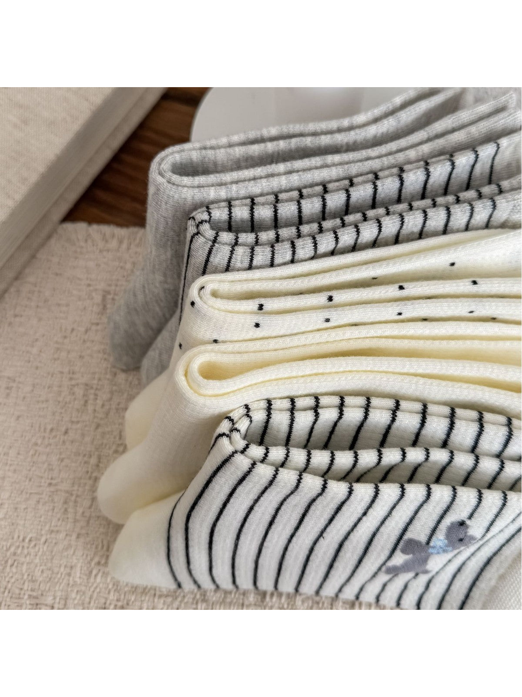 Close-up of folded striped, dotted and plain socks showing their knit edges