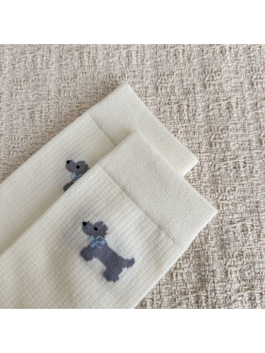 Close-up of the ivory sock cuffs and gray dog motifs