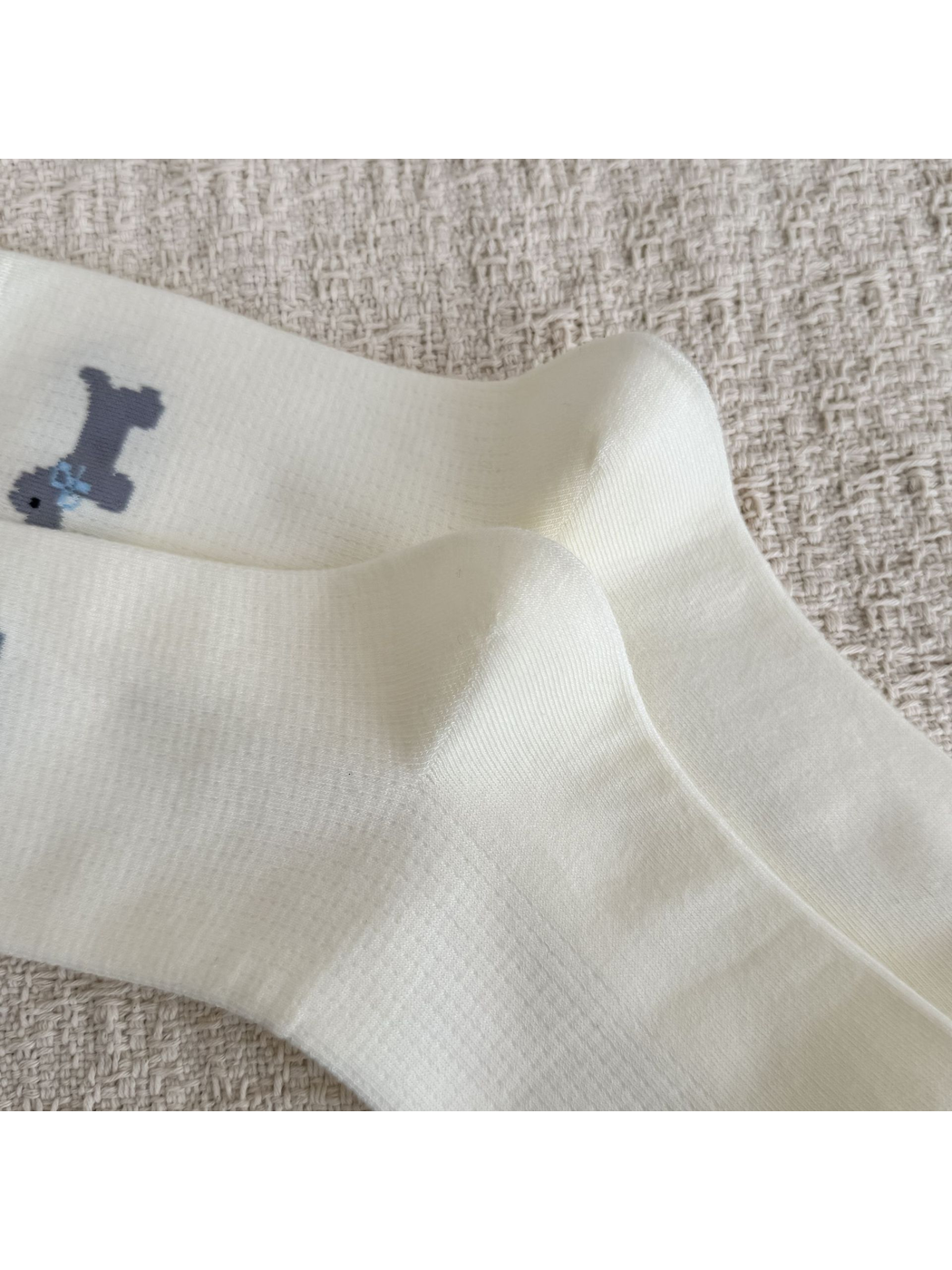 Close-up of the shaped heels and fine knit texture on ivory socks