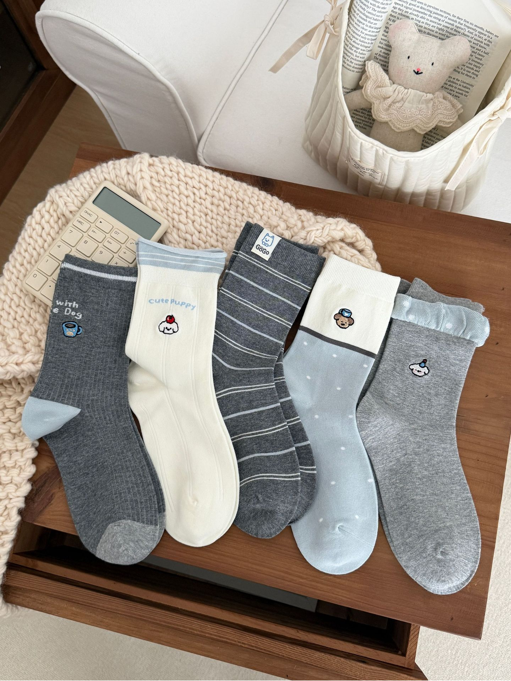 Five crew sock styles displayed together in ivory, light blue and gray