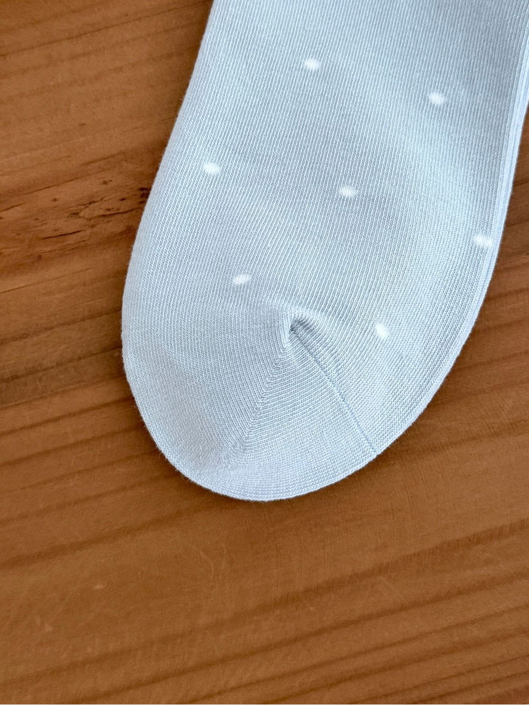 Close-up of the Bear Dots sock toe seam, fine knit texture and white dot pattern