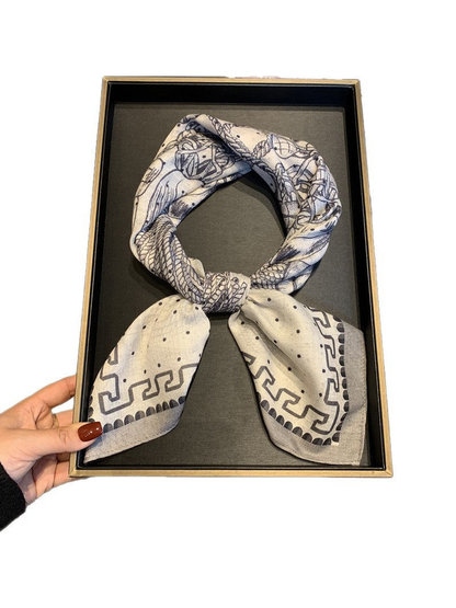 Ivory and navy patterned scarf tied in a loop against a white background