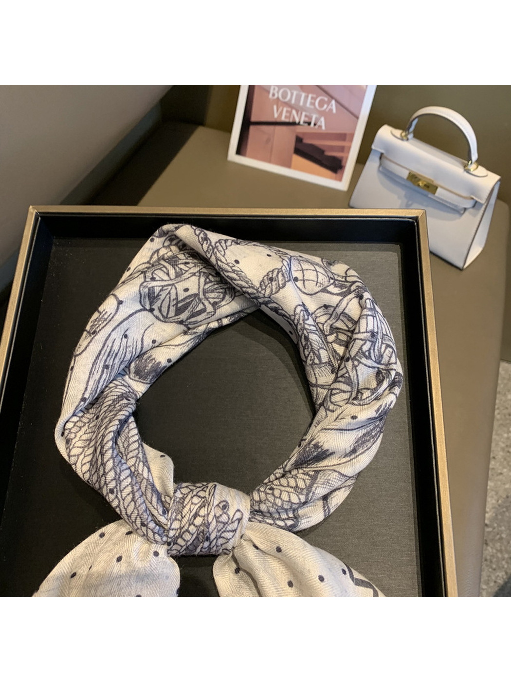 Close-up of the scarf knot and detailed navy motif illustrations