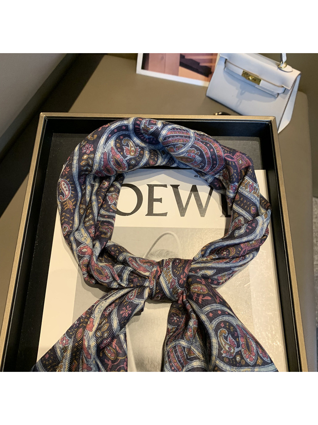 Close-up of the burgundy and navy paisley scarf knot and patterned folds