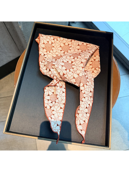 Orange Red floral openwork triangle scarf displayed on a black tray