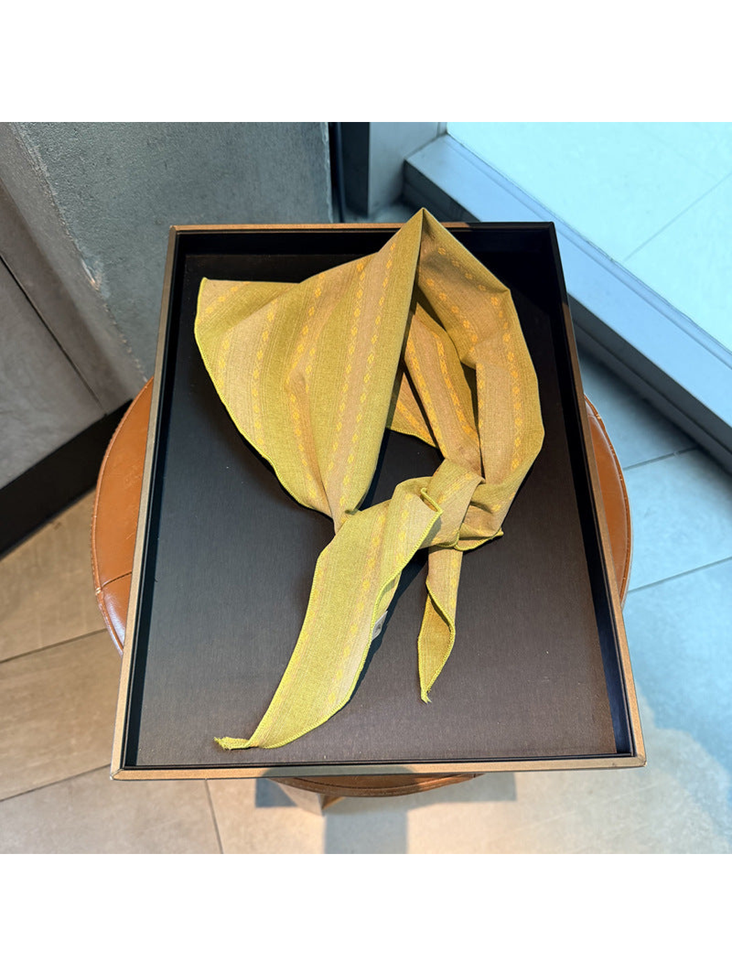 Yellow striped scarf tied on a display tray