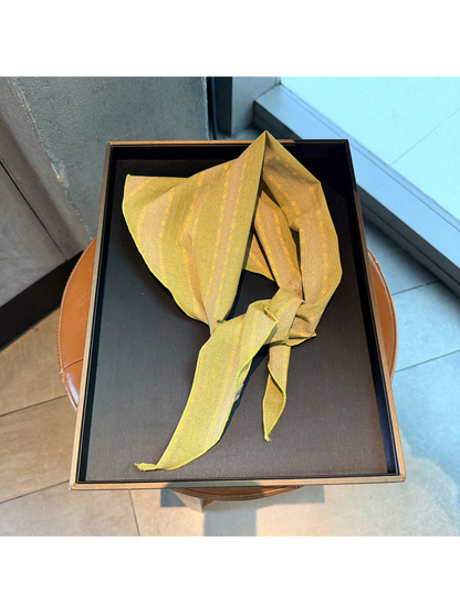 Yellow striped scarf tied on a display tray