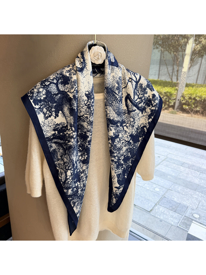 Navy and ivory triangle scarf draped over a cream sweater