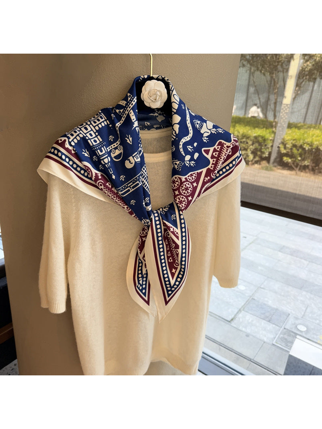 Navy, burgundy and ivory patterned scarf tied over a cream top