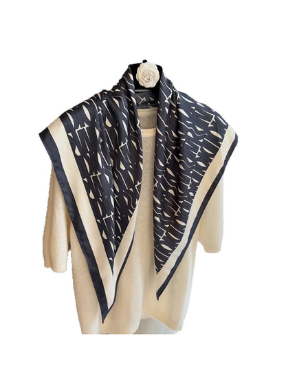Black and ivory geometric triangle scarf displayed over a cream sweater
