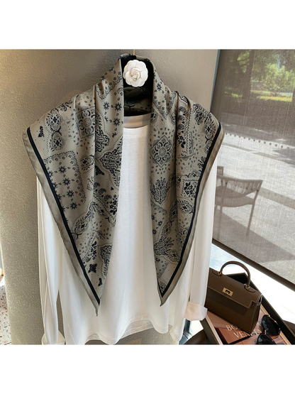 Gray paisley scarf draped loosely over a white top