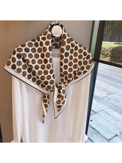 Brown polka-dot scarf tied over a white top