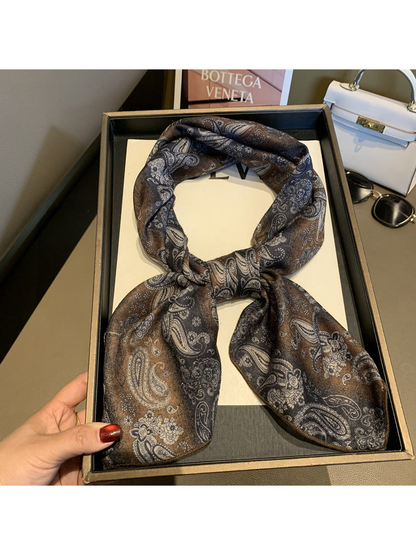 Brown, charcoal and cream paisley scarf arranged in a loose necktie knot