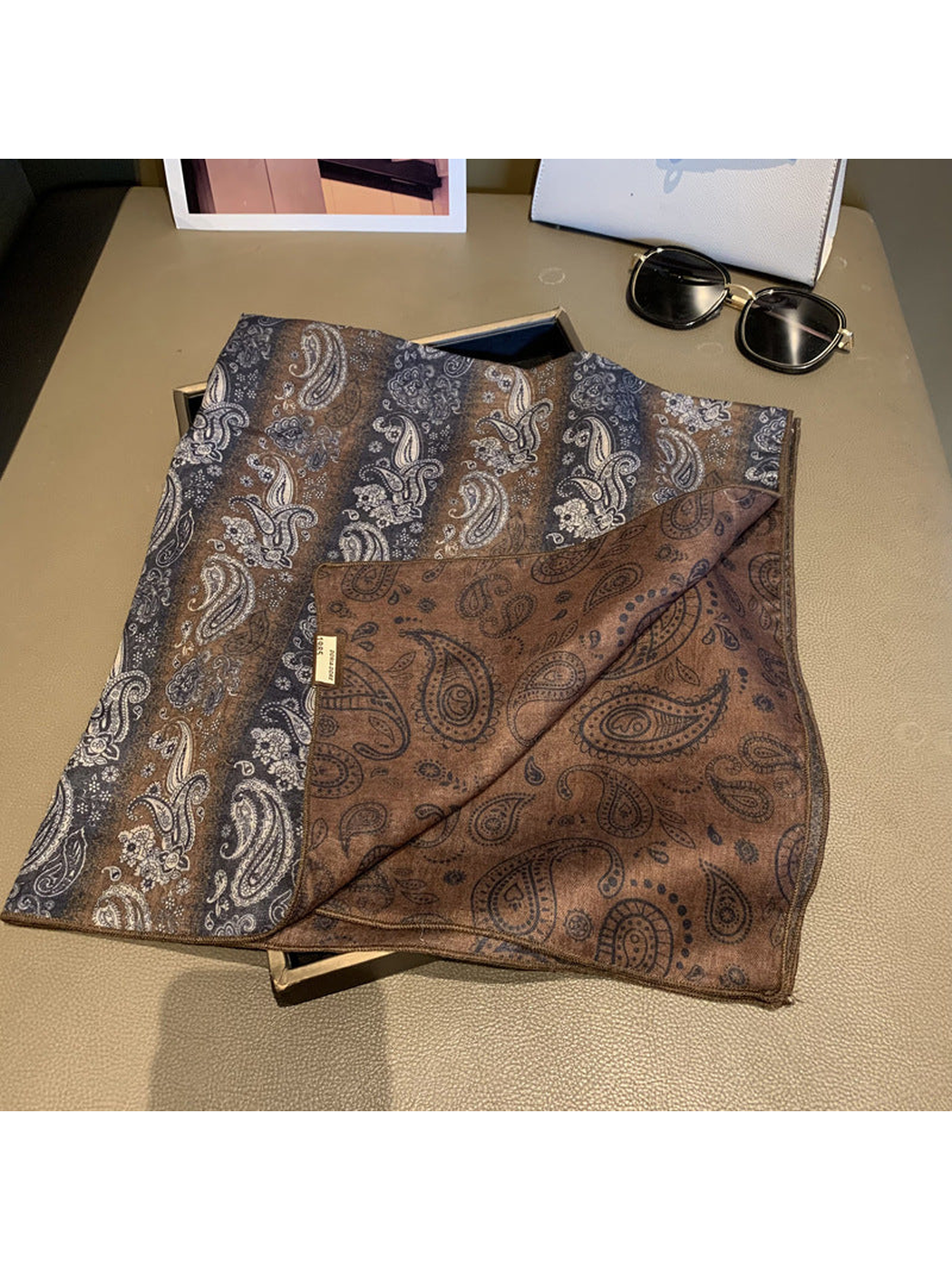 Close-up of the scarf front and contrasting brown reverse with paisley outlines